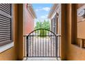 Wrought iron entry gate to home's front door and walkway surrounded by colorful stucco exteriors at 9349 Sweet Maple Ave, Orlando, FL 32832