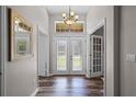 Inviting foyer with wood-look floors, transom windows, and double glass entry doors at 1124 Shadowbrook Trl, Winter Springs, FL 32708