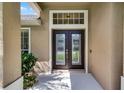 Elegant front door with decorative glass inserts and transom window, framed by columns at 1124 Shadowbrook Trl, Winter Springs, FL 32708