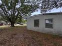 The side exterior shows a simple design with a white painted wall, two windows, and yard at 11625 Churchill St, Orlando, FL 32817