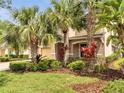 Beautiful home with lush tropical landscaping, manicured lawn, and covered entryway at 11885 Padua Ln, Orlando, FL 32827