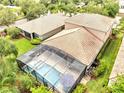 Aerial view of screened-in pool and home, showing backyard with lush landscaping at 11885 Padua Ln, Orlando, FL 32827