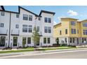 Contemporary white townhome showcases clean lines and dark accents, complemented by fresh landscaping at 15483 Hamlin Park Drive, Winter Garden, FL 34787