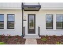 Close-up of home's front entrance showcases a modern door and clean design with landscaped walkway at 15483 Hamlin Park Drive, Winter Garden, FL 34787