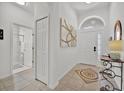 Bright foyer boasts tile flooring, high ceilings, and stylish decor; access to bathroom at 162 Plumoso Loop, Davenport, FL 33897