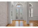 Bright foyer with decorative glass double doors, hardwood floors, and clerestory windows at 1803 Glenbay Ct, Windermere, FL 34786