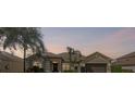 Exterior shot of single-story home with landscaped yard taken at dusk at 235 Largovista Dr, Oakland, FL 34787