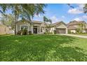 Charming single-story home features a manicured lawn, mature landscaping and two car garage at 235 Largovista Dr, Oakland, FL 34787