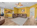 Spacious living room featuring a leather sectional, wood floors, and bright yellow walls at 235 Largovista Dr, Oakland, FL 34787