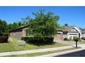 View of the side of the home showing the two-car garage and landscaping at 245 Brunswick Dr, Davenport, FL 33837