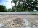 Large, private backyard area enclosed by a white fence and mature trees, offering ample space at 2531 Blue Wave Pl, Oviedo, FL 32765