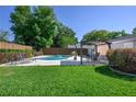 Beautiful backyard featuring a pool, lounge chairs, and covered outdoor dining area with lush green grass and landscaping at 3029 Peel Ave, Orlando, FL 32806