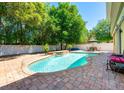 Backyard pool with brick pavers, enclosed by a white fence and lush landscaping at 310 Stakes Ct, Deland, FL 32724