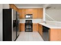 Functional kitchen featuring oak cabinets and modern black appliances at 3542 Shallot Dr # 108, Orlando, FL 32835