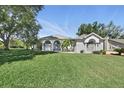 Charming one-story home with well-maintained lawn, mature trees, and architectural details at 392 Bayberry Dr, Polk City, FL 33868