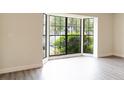 Bright living room with a large bay window, new gray laminate floors, and fresh neutral paint at 6021 Village Cir # 6021, Orlando, FL 32822