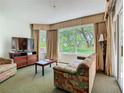 Cozy living room with large windows, curtains, and comfortable seating, creating a relaxing atmosphere at 6403 Parc Corniche Dr # 4114, Orlando, FL 32821