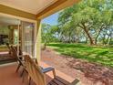A condo patio showing peaceful parklike view with mature trees, and chairs for relaxing outdoors at 6403 Parc Corniche Dr # 4114, Orlando, FL 32821