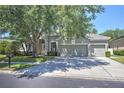 Attractive single-Gathering home with a three-car garage, mature trees, and well-maintained lawn at 7167 Winding Lake Cir, Oviedo, FL 32765