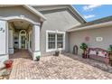 Welcoming front entry with arched porch, brick pavers, and a charming seating area at 725 High Vista Dr, Davenport, FL 33837