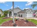 Lovely home featuring a paver driveway, tropical landscaping, and an attached two-car garage at 725 High Vista Dr, Davenport, FL 33837