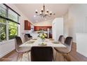 Elegant dining area with chandelier, marble table, and views of the green outdoor scenery at 7264 Hawksnest Blvd, Orlando, FL 32835