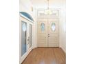 Elegant front door with decorative glass inserts, complemented by wood flooring and ample natural light at 7264 Hawksnest Blvd, Orlando, FL 32835