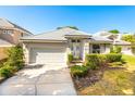 Charming single-story home with a well-maintained lawn, attached garage, and white tiled roof at 7264 Hawksnest Blvd, Orlando, FL 32835