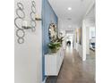 Inviting hallway with blue accent wall, decorative mirror, and elegant console table at 756 Mocking Jay Ln, St Cloud, FL 34771