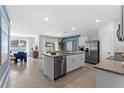 Open-concept kitchen featuring a granite island, stainless steel appliances, and a view to the living area at 756 Mocking Jay Ln, St Cloud, FL 34771