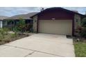 Spacious driveway leading to a two-car garage with stone and siding exterior at 8129 Granada Blvd, Orlando, FL 32836
