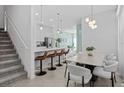 Bright dining area features a modern table, stylish chairs, and a view of the open kitchen with barstool seating at 10436 Ebb Tide Lane, Orlando, FL 32821