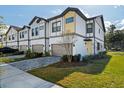 Modern townhome showcasing a two-car garage, neutral paint, and a well manicured lawn at 10436 Ebb Tide Lane, Orlando, FL 32821