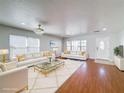 Bright and airy living room featuring white sofas with gold accents, wood floors and modern light fixture at 1176 Liberty Hall Dr, Kissimmee, FL 34746