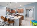 Bright kitchen featuring an island with seating, stainless steel appliances, and ample counter space at 136 Jetty Way, Davenport, FL 33897