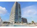 Luxurious pool deck with comfortable lounge chairs and a clear view of the modern high-rise condo building at 150 E Robinson St # 1219, Orlando, FL 32801