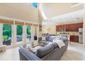 Bright living room featuring high ceilings, a cozy sofa, and a view of the outdoor patio at 1563 Song Sparrow Ct, Sanford, FL 32773