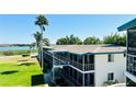 Two-story condo building featuring outdoor walkways, screened-in patios, and lush landscaping with lake views at 1600 W Lake Parker Dr # C24, Lakeland, FL 33805