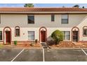 Attractive townhouse exterior with a red-tiled roof, manicured landscaping, and assigned parking at 1631 Long Ridge Ct # 268, Orlando, FL 32807