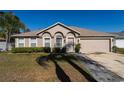 Inviting single-story home featuring well-maintained landscaping and a two-car garage at 1632 Lansfield Ave, Deltona, FL 32738
