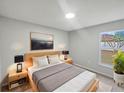 Bright bedroom with large window, neutral walls, bedside tables, and artwork above the headboard at 1730 Lochshyre Loop, Ocoee, FL 34761
