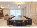 Open-concept dining room with a long table and seating for ten under an elegant chandelier at 2123 Lelani Cir, Davenport, FL 33897