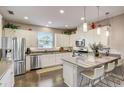 Bright kitchen with stainless appliances, white cabinetry, bar seating and hardwood flooring at 223 Silver Maple Rd, Groveland, FL 34736