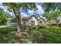 Beautiful single-Gathering home with lush front lawn, stone accents, a tile roof, and an attached garage at 25519 Hawks Run Ln, Sorrento, FL 32776