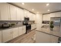 Modern kitchen featuring quartz countertops, stainless steel appliances, and white cabinets at 2825 Muller Oak Loop, Ocoee, FL 34761