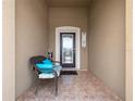 Cozy covered front porch with a comfortable chair, decorative accents, and tiled flooring at 3505 Rhapsody St, St Cloud, FL 34772