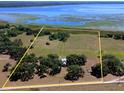 Aerial shot of a large, open parcel of land near the lake, marked by yellow borders at 3650 Lake Tohopekaliga Rd, St Cloud, FL 34772