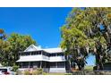 Charming two-story home featuring a screened porch, mature trees, and a ramp entrance at 3650 Lake Tohopekaliga Rd, St Cloud, FL 34772