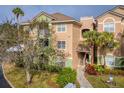 Multi-story condo exterior with well-maintained landscaping, mature trees, and a private balcony at 4897 Cypress Woods Dr # 6314, Orlando, FL 32811