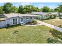 Aerial view of a cozy home with a covered parking area and well-maintained lawn at 4908 Keith Pl, Orlando, FL 32808